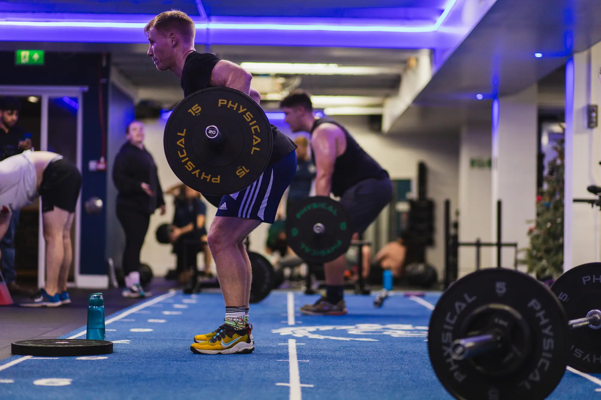 Multiple people in the process of doing barbell rows